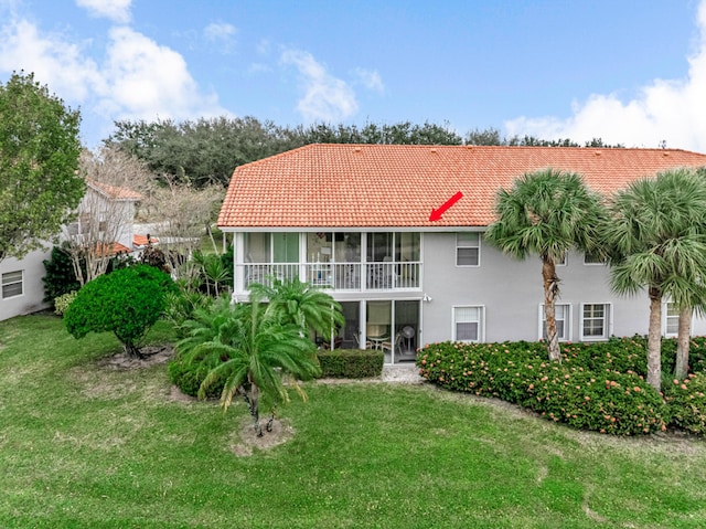 back of house featuring a yard and a sunroom