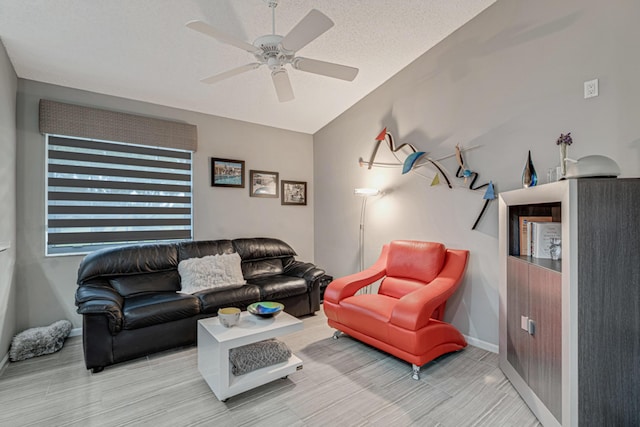 living room featuring ceiling fan and a textured ceiling