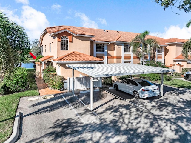 9817 Seacrest Cir Unit 201, Boynton Beach, FL 33437 - view of front facade with a tile roof, stucco siding, and covered and uncovered parking