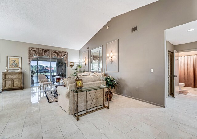 living room with a textured ceiling and vaulted ceiling