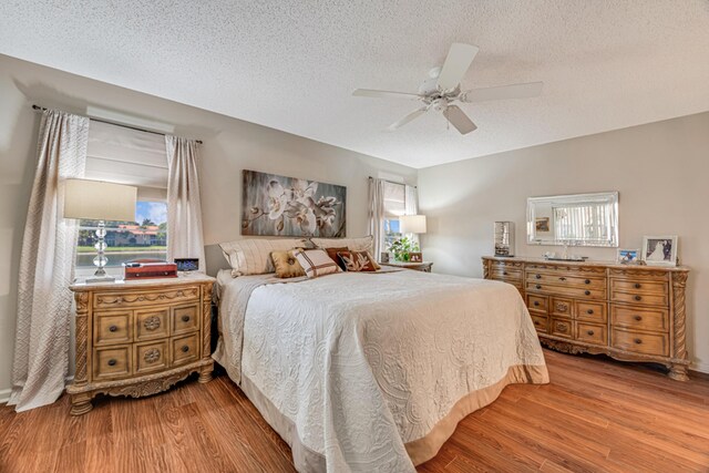 carpeted bedroom with a textured ceiling, ceiling fan, and a closet