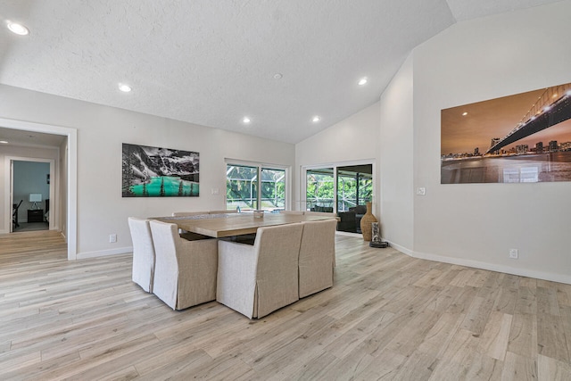 unfurnished dining area featuring high vaulted ceiling, a textured ceiling, and light wood-type flooring