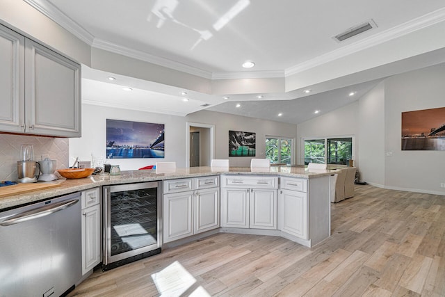 kitchen featuring kitchen peninsula, light wood-type flooring, tasteful backsplash, stainless steel dishwasher, and beverage cooler