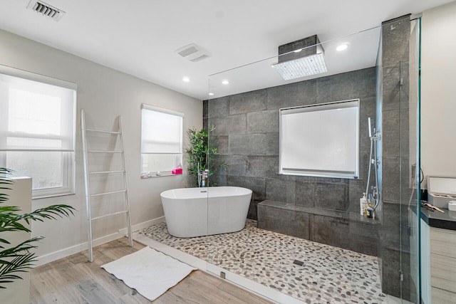 bathroom featuring hardwood / wood-style floors and independent shower and bath