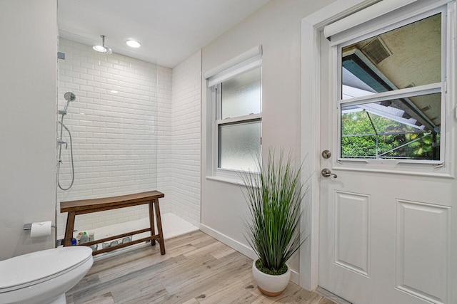 bathroom featuring hardwood / wood-style floors, toilet, and a shower