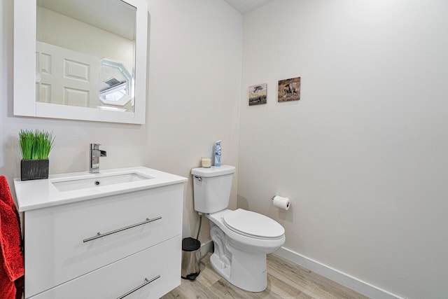 bathroom featuring wood-type flooring, vanity, and toilet