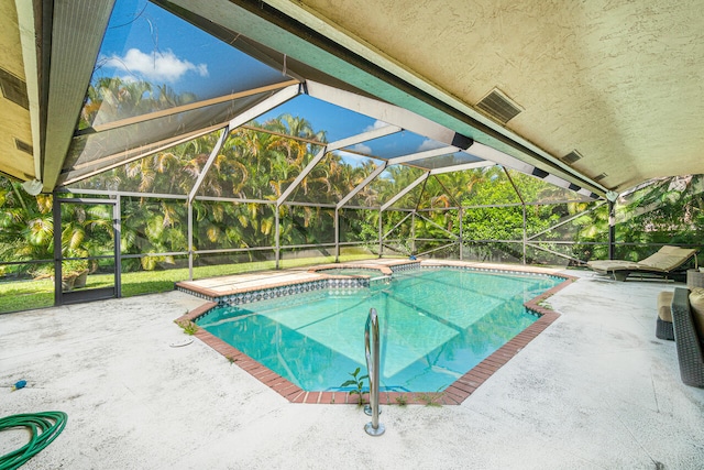 view of swimming pool with an in ground hot tub, glass enclosure, and a patio area