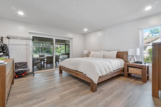 bedroom with access to exterior and light hardwood / wood-style floors