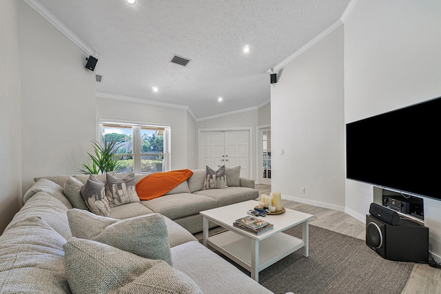 living room with vaulted ceiling, crown molding, light hardwood / wood-style flooring, and a textured ceiling