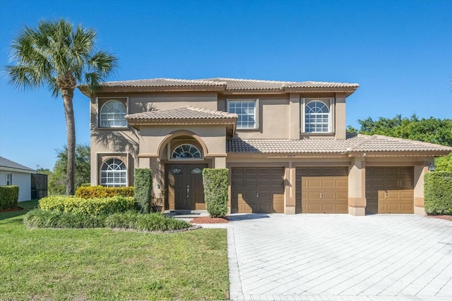 mediterranean / spanish house featuring a front yard and a garage