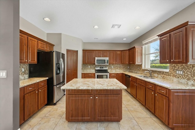 kitchen featuring a center island, sink, light tile patterned floors, light stone counters, and stainless steel appliances