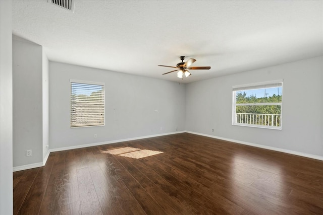 unfurnished room featuring plenty of natural light, dark hardwood / wood-style floors, and ceiling fan