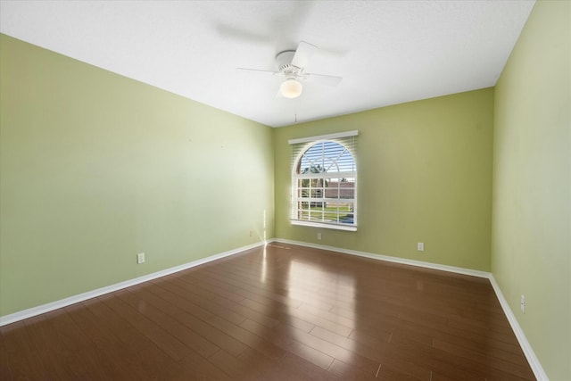 empty room with dark hardwood / wood-style flooring and ceiling fan