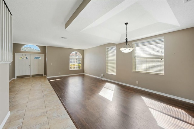 tiled entrance foyer with a raised ceiling