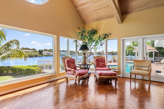 sunroom with vaulted ceiling with beams, a healthy amount of sunlight, and a water view