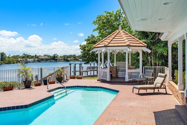 view of swimming pool featuring a gazebo, a fenced in pool, a water view, and a patio