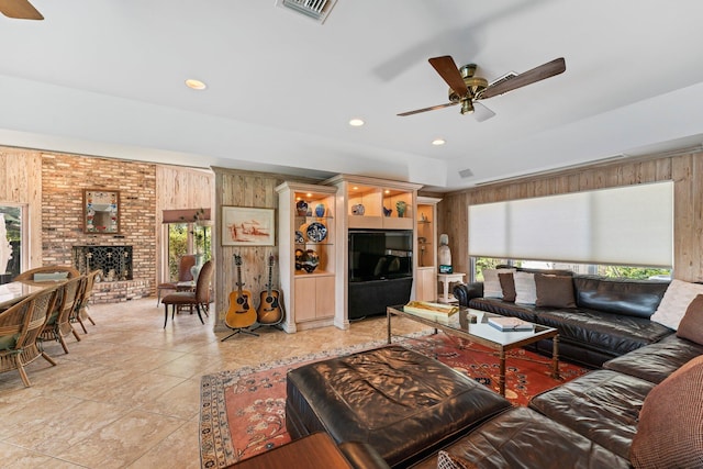 living area with visible vents, plenty of natural light, and wooden walls