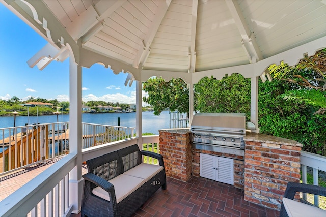 view of patio featuring a gazebo, a grill, exterior kitchen, and a water view