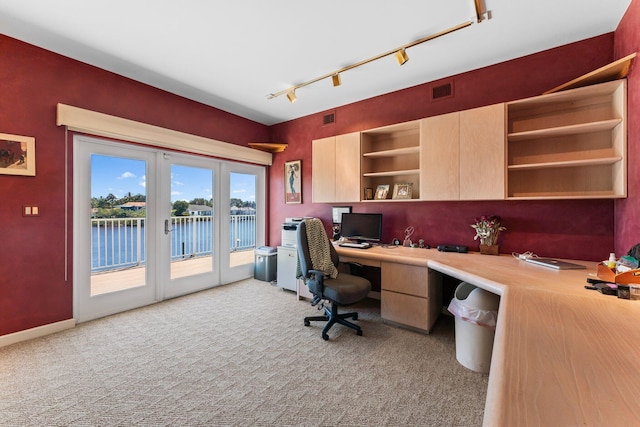 office area featuring light carpet, built in desk, rail lighting, and visible vents