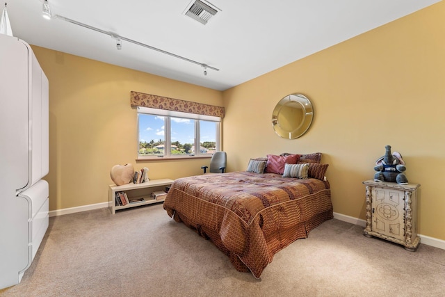 bedroom featuring visible vents, light carpet, baseboards, and track lighting