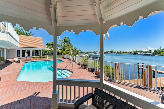 view of swimming pool with fence, a fenced in pool, french doors, a water view, and a patio area