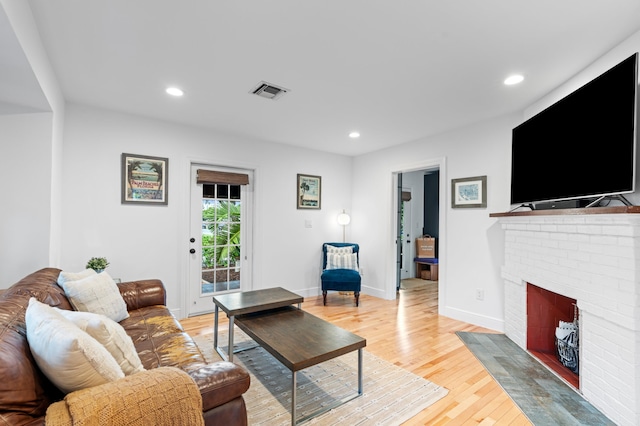 living room with light hardwood / wood-style flooring and a fireplace