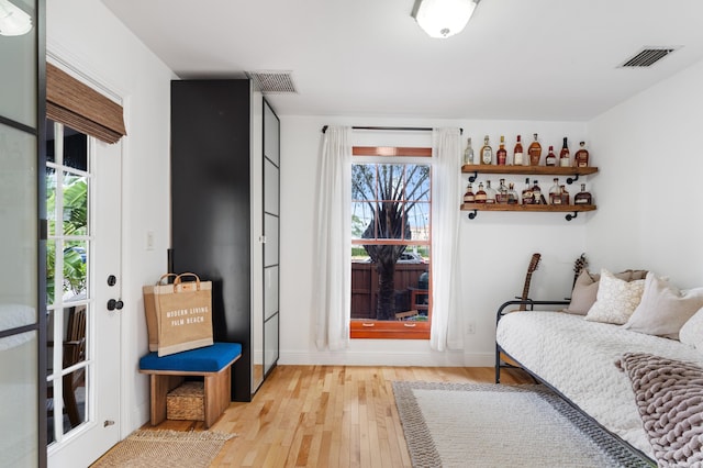 sitting room with indoor bar and light hardwood / wood-style flooring