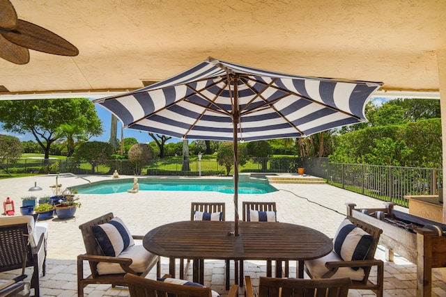 view of pool with ceiling fan and a patio