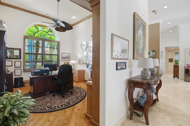 home office featuring ceiling fan, crown molding, and a towering ceiling