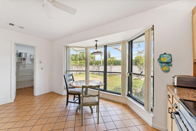 tiled dining space with ceiling fan