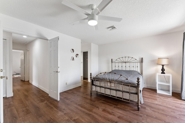 bedroom featuring a textured ceiling, ceiling fan, and dark wood-type flooring