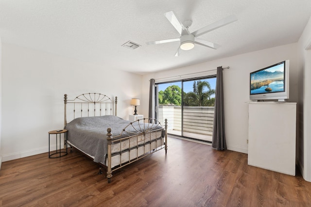 bedroom featuring access to outside, ceiling fan, dark wood-type flooring, and a textured ceiling