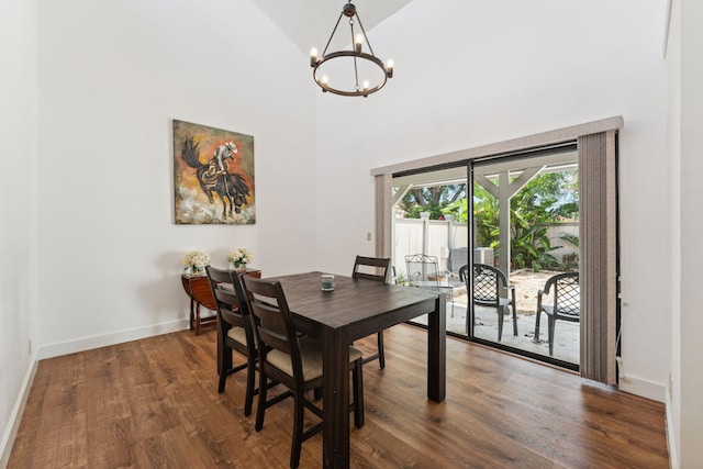 dining space with high vaulted ceiling, dark wood-type flooring, and an inviting chandelier