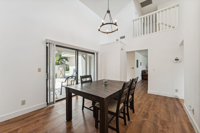 dining room with high vaulted ceiling, dark wood-type flooring, and a notable chandelier