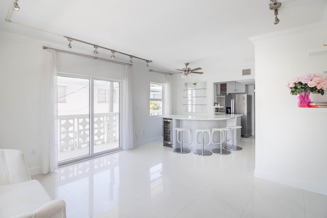 900 Euclid Ave Unit 8, Miami Beach, FL 33139 - kitchen with a breakfast bar, stainless steel refrigerator with ice dispenser, light tile patterned flooring, ornamental molding, and baseboards