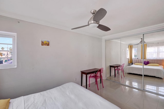 bedroom with tile patterned flooring, ceiling fan, multiple windows, and a closet