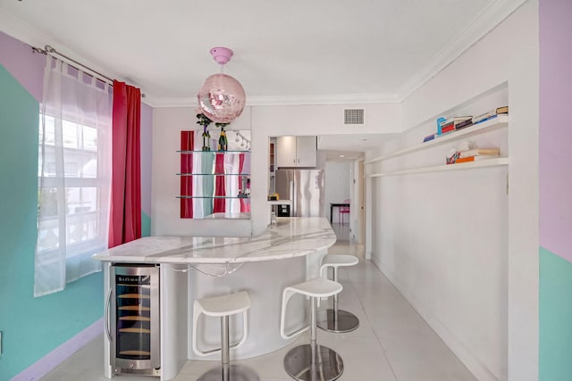 kitchen featuring stainless steel fridge, light tile patterned floors, crown molding, and beverage cooler