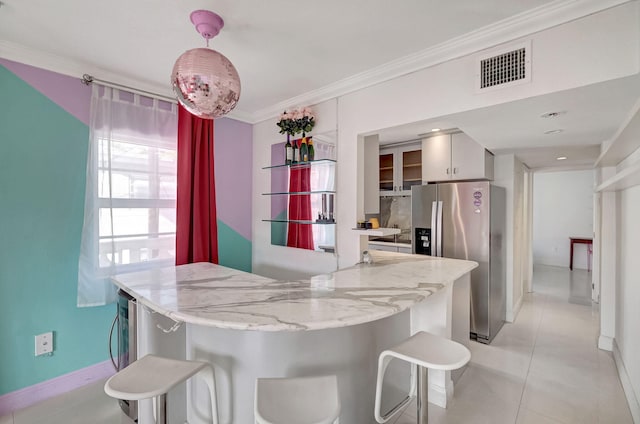 kitchen featuring white cabinetry, light stone counters, stainless steel refrigerator with ice dispenser, kitchen peninsula, and light tile patterned floors