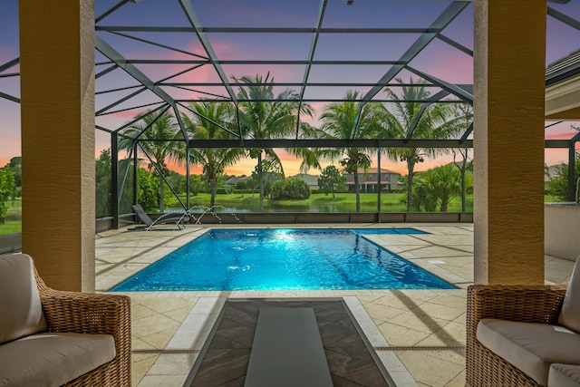 pool at dusk with a lanai, pool water feature, and a patio