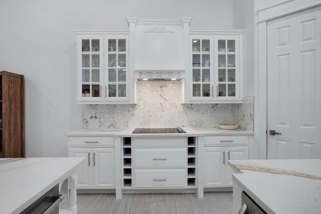 bar with black electric cooktop, white cabinetry, and decorative backsplash