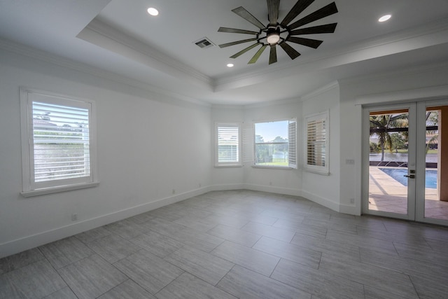 unfurnished room with french doors, a raised ceiling, ceiling fan, and crown molding