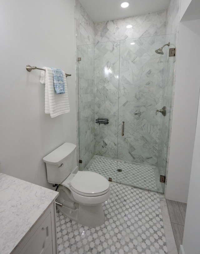 bathroom with vanity, an enclosed shower, and toilet