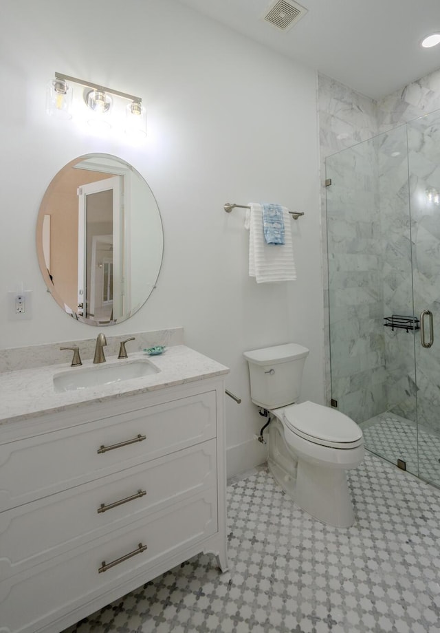 bathroom featuring vanity, toilet, and a shower with shower door