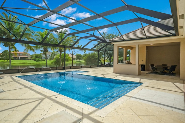 view of swimming pool with pool water feature, a water view, a patio, and a lanai