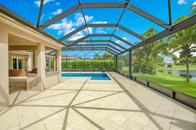 view of swimming pool with a patio, a water view, and glass enclosure