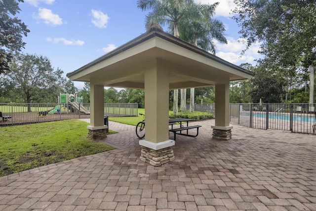 view of community featuring a gazebo, a pool, a yard, a playground, and a patio