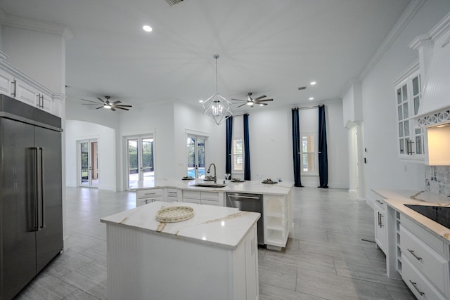 kitchen featuring kitchen peninsula, appliances with stainless steel finishes, sink, pendant lighting, and a center island