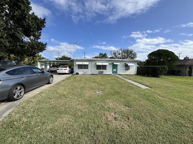 view of front of home with a front yard and a carport