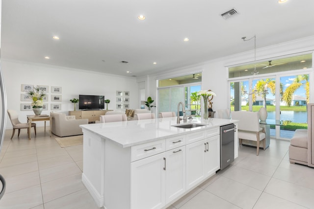 kitchen featuring sink, white cabinets, decorative light fixtures, a kitchen island with sink, and crown molding