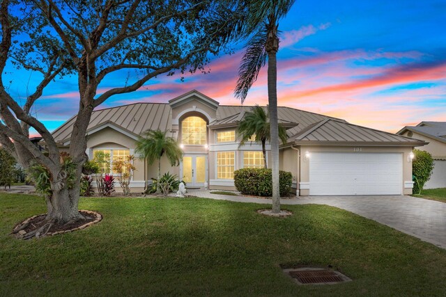 view of front of property featuring a garage and a lawn